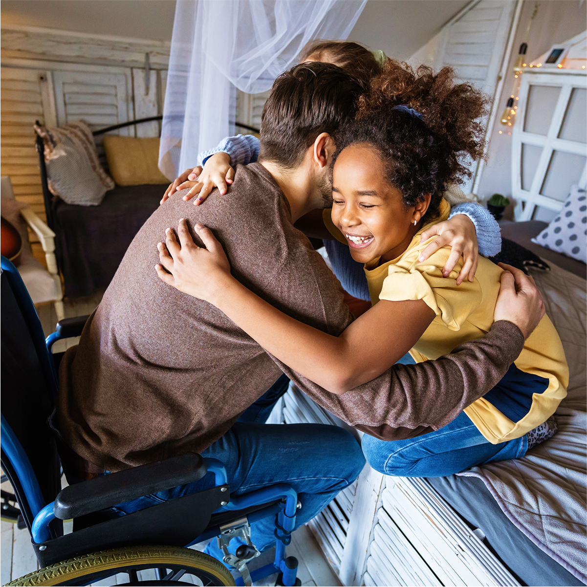 Child and adult hugging on bed, promoting warmth and inclusivity in a cozy room setting.