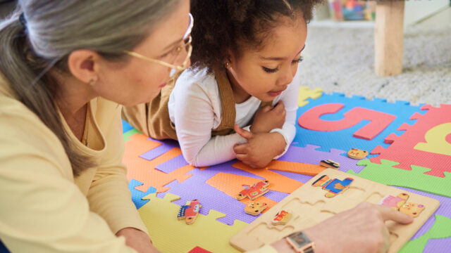 Child and adult playing with educational toys on colorful foam mats, enhancing learning and creativity in a playful environment.