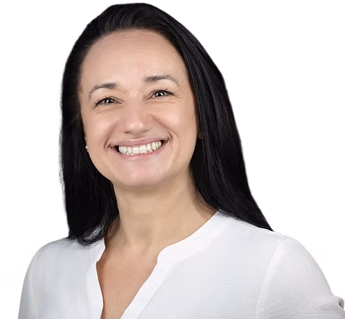 Smiling person with long dark hair wearing a white shirt against a black background.